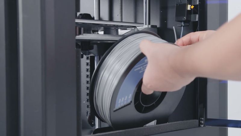 Loading filament into the printer.