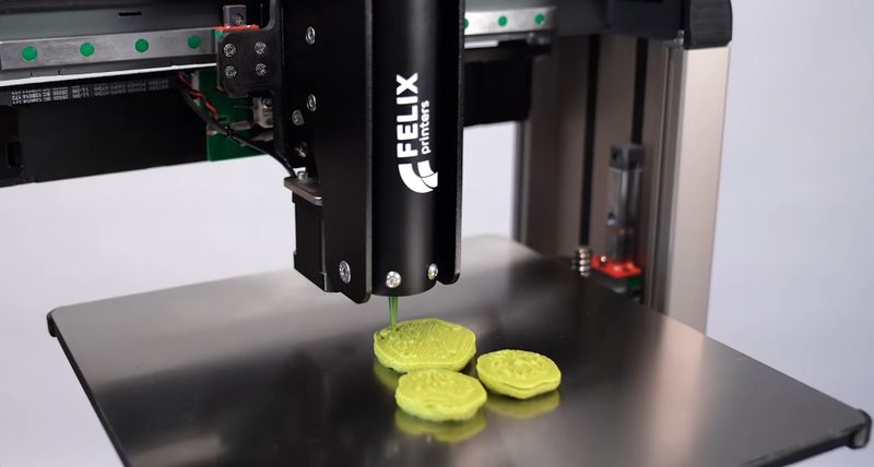 The FELIX food 3D printer in the process of printing food patterns.
