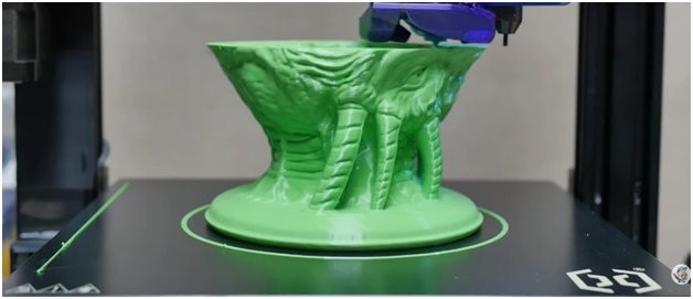 a 3d printing of a green model on Artillery Genius Pro 3D printer