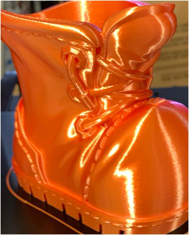 An orange shoe is printed on the Artillery Genius 3D printer