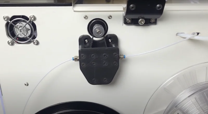 3D printer component detail with tubing, fan, and spool on Anisoprint Composer A4.