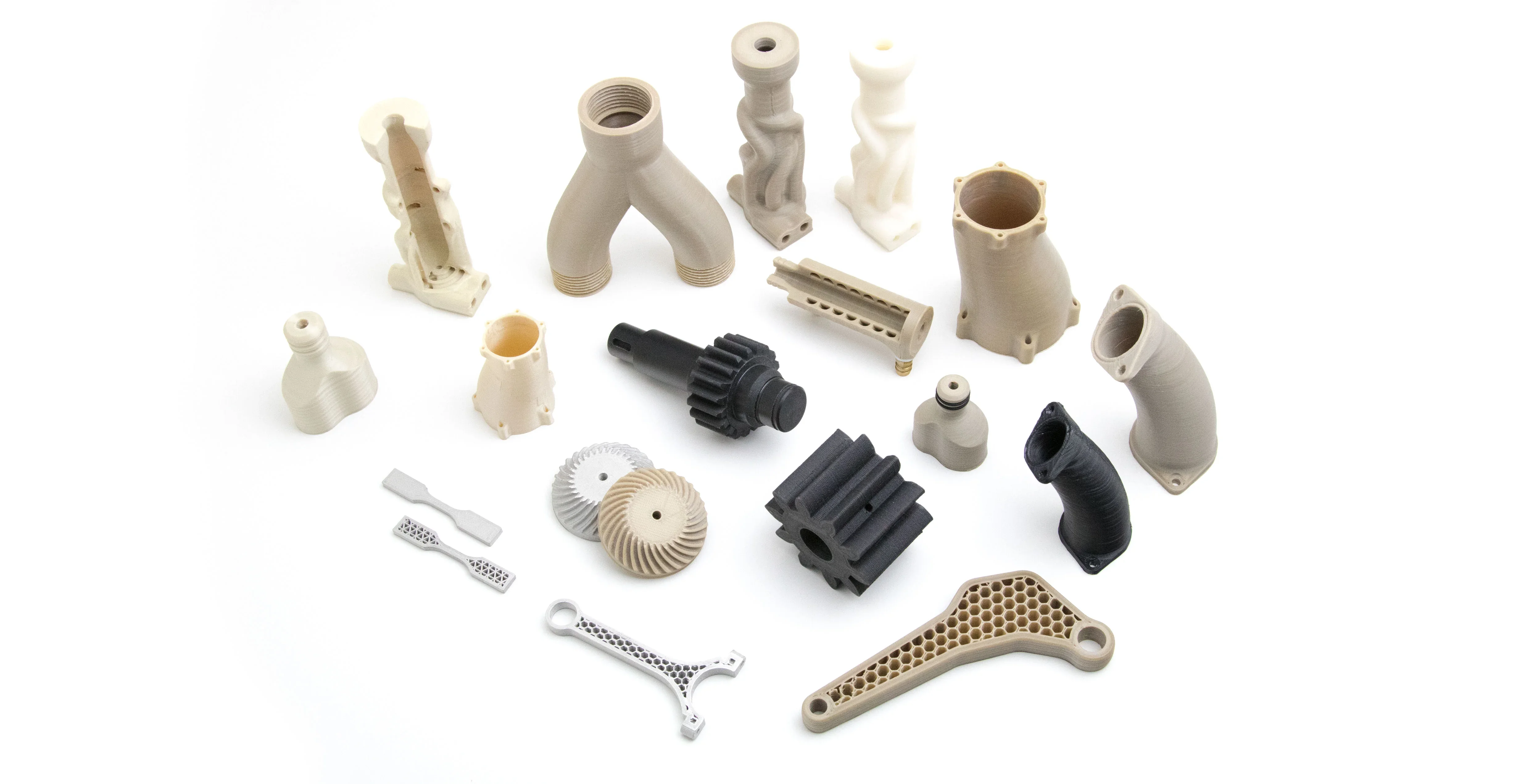 Various 3D printed parts created by Apium P400, including gears and pipes, showcasing precision and diversity in design on a white background.