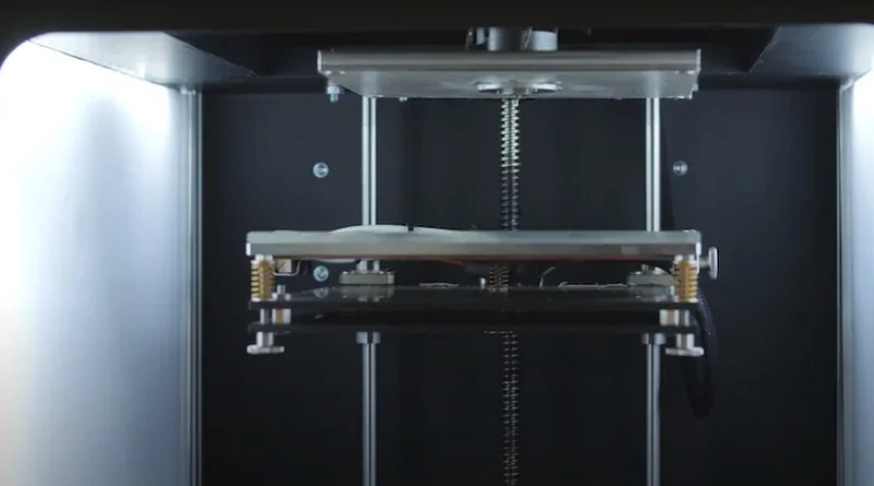 Apium P400 3D printer interior view, showcasing vertical rods and printing mechanism, designed for creating precise parts.