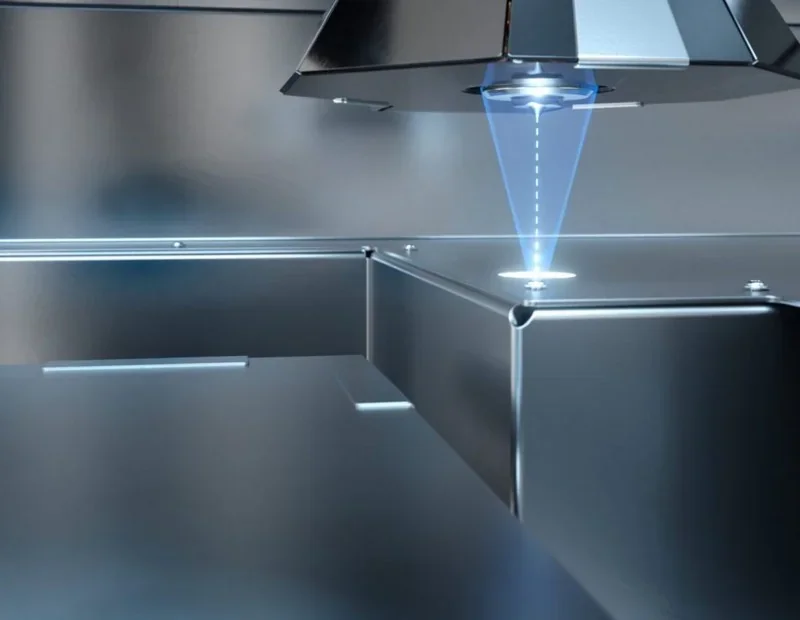 Apium P400 3D printer showcasing precision laser technology in a sleek metallic setup, producing intricate parts.