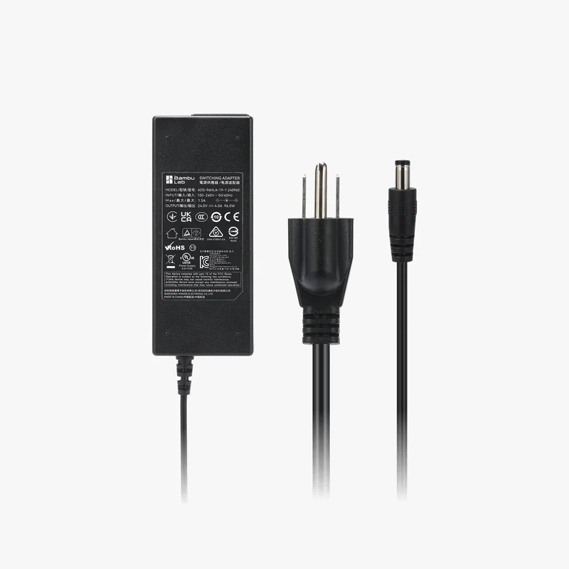 Bambu H2D power adapter with plug and cable, black with printed specifications, against a white background.