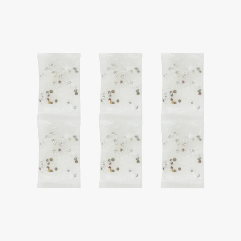 White desiccant packets aligned vertically, featuring protective text and scattered internal granules, associated with Bambu H2D 3D printer.
