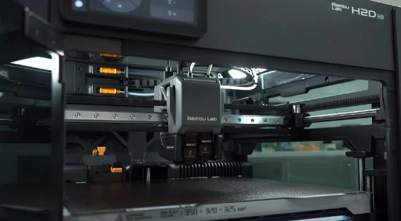 Bambu Lab H2D Pro 3D printer with a central printhead, showcasing its build area and mechanical components, designed for precise printing.