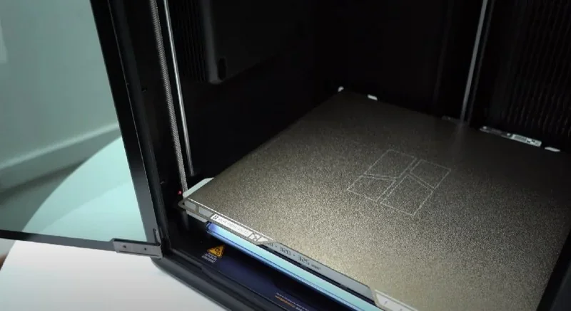 Bambu Lab H2D Pro 3D printer with an open chamber, showing the build plate; sleek design emphasizes the advanced technology and functionality.