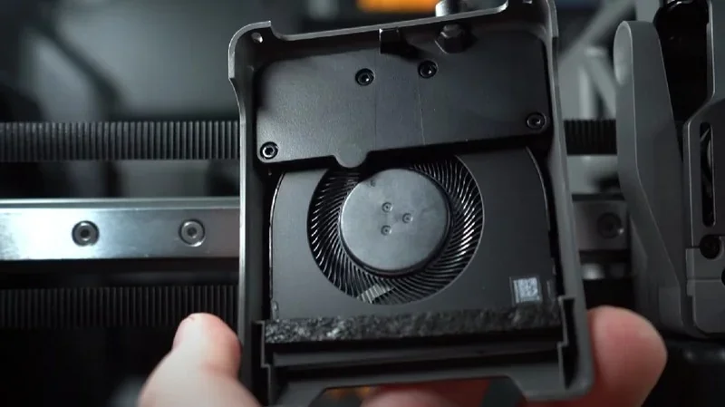 Bambu Lab H2D Pro component with cooling fan and intricate design, highlighting internal mechanism, part of a 3D printer setup.