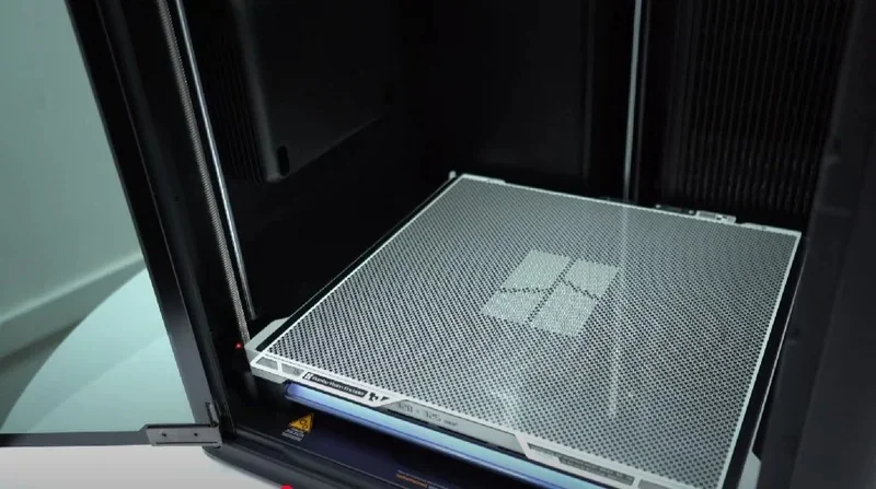 Bambu Lab H2D Pro 3D printer's interior with a print bed, showing intricate mesh design, indicating detailed creation capability.