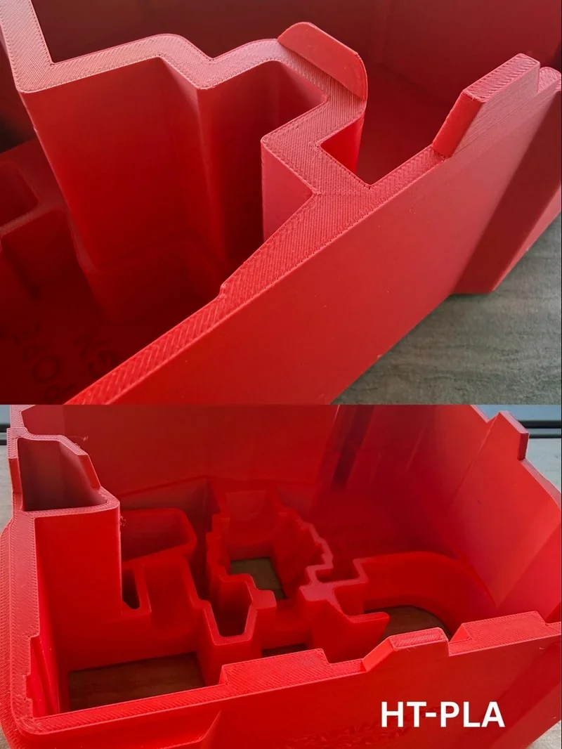 Red 3D-printed objects with detailed geometries, created by Bambu Lab H2S; labeled HT-PLA, shown on a wooden surface.