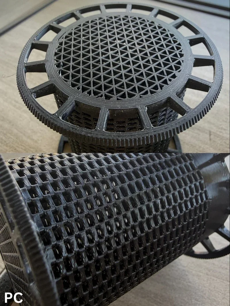 Black 3D-printed lattice spool part by Bambu Lab H2S, showcasing intricate geometric patterns on a wooden surface.