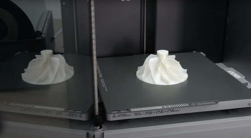 Bambu Lab X1 3D printer showcasing a white spiral object on its print bed, highlighting precision and capabilities.