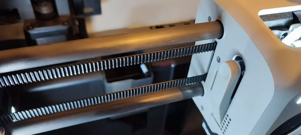 Bambu Lab X1 3D printer detail view showing belt mechanism and components, highlighting precision engineering and advanced design elements.