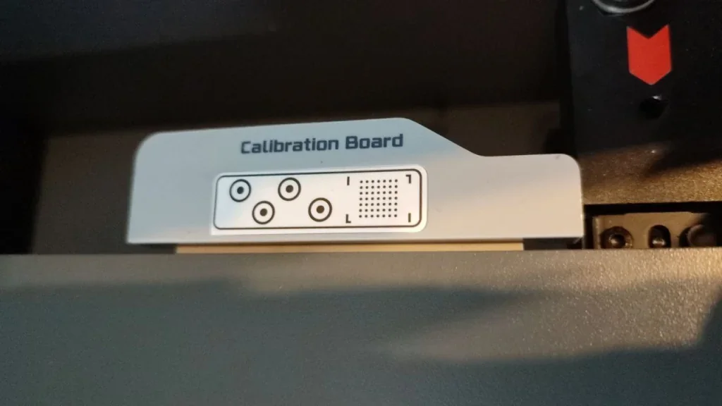 Bambu Lab X1 calibration board with pattern and markings inside printer, essential for precision in 3D printing.