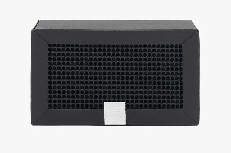 Black 3D printed vented box, likely an accessory or part created by the Bambu Lab X1 printer, featuring hexagonal holes and a white pull tab.