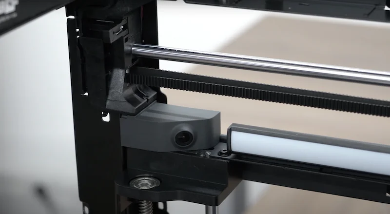 Bambu P1P 3D printer close-up shows intricate mechanical parts and components, showcasing technical precision and design elements.