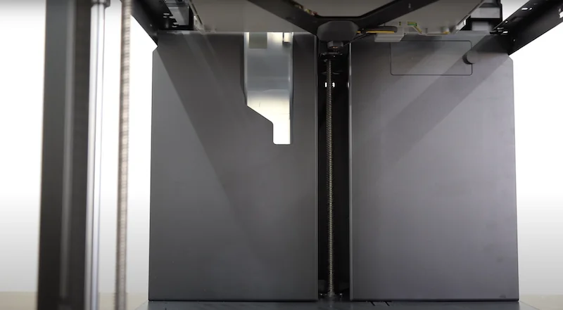 Bambu P1P 3D printer interior view showing dual enclosures and vertical rods, emphasizing sleek design and functionality.