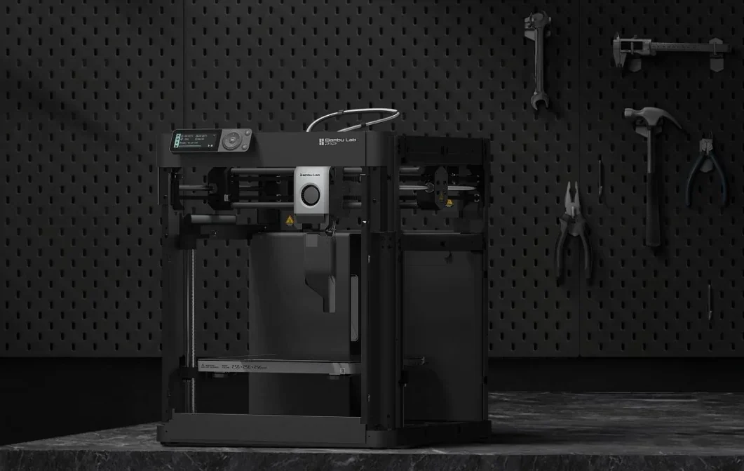 Bambu P1P 3D printer on a dark workbench with tools on a pegboard backdrop, showcasing its sleek design.