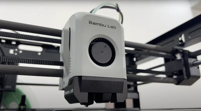 Bambu Lab P1P 3D printer in action, showcasing its advanced print head and sleek design, with branding visible in a modern lab setting.