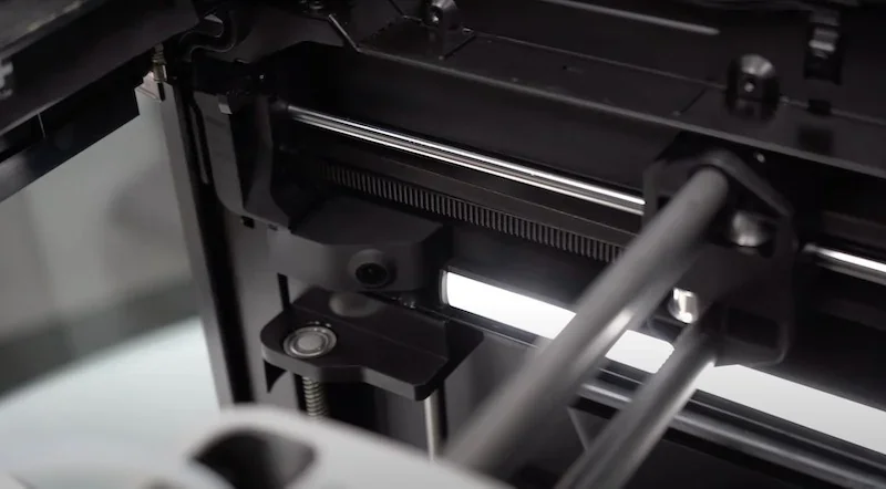 Bambu P1S 3D printer mechanism with precision rods and components in detailed close-up, highlighting engineering and design features.