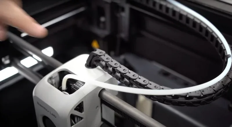 Bambu P1S 3D printer detail showing filament feeding mechanism with branding.