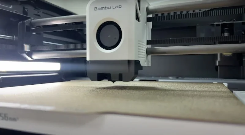 Bambu P1S 3D printer in action, showing extruder moving across print bed; "Bambu Lab" branding visible.