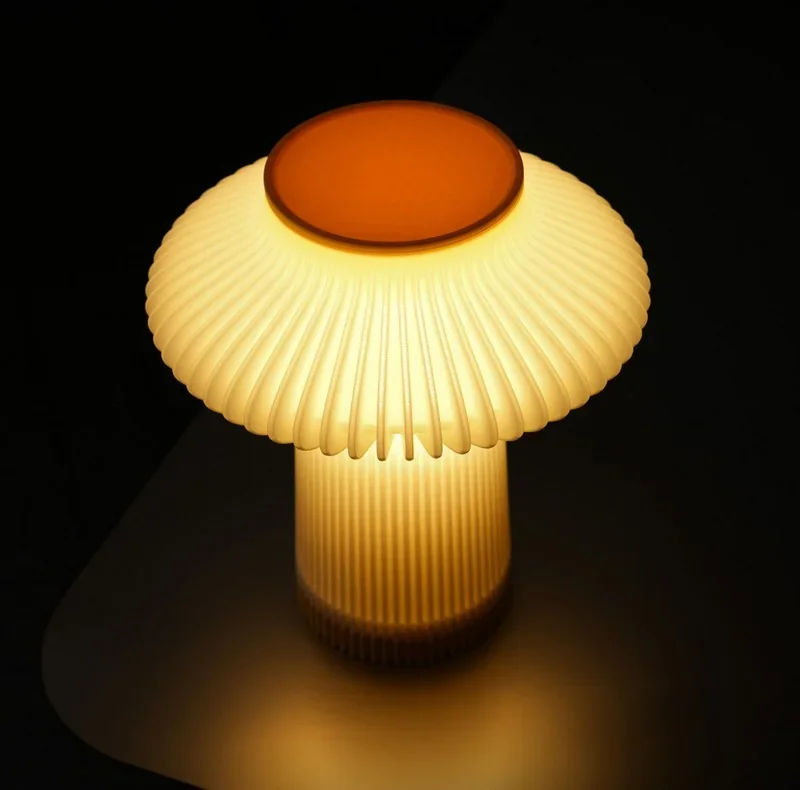 Glowing mushroom-shaped lamp created by Bambu P2S 3D printer, featuring a ribbed design and warm orange center, set against a dark background.