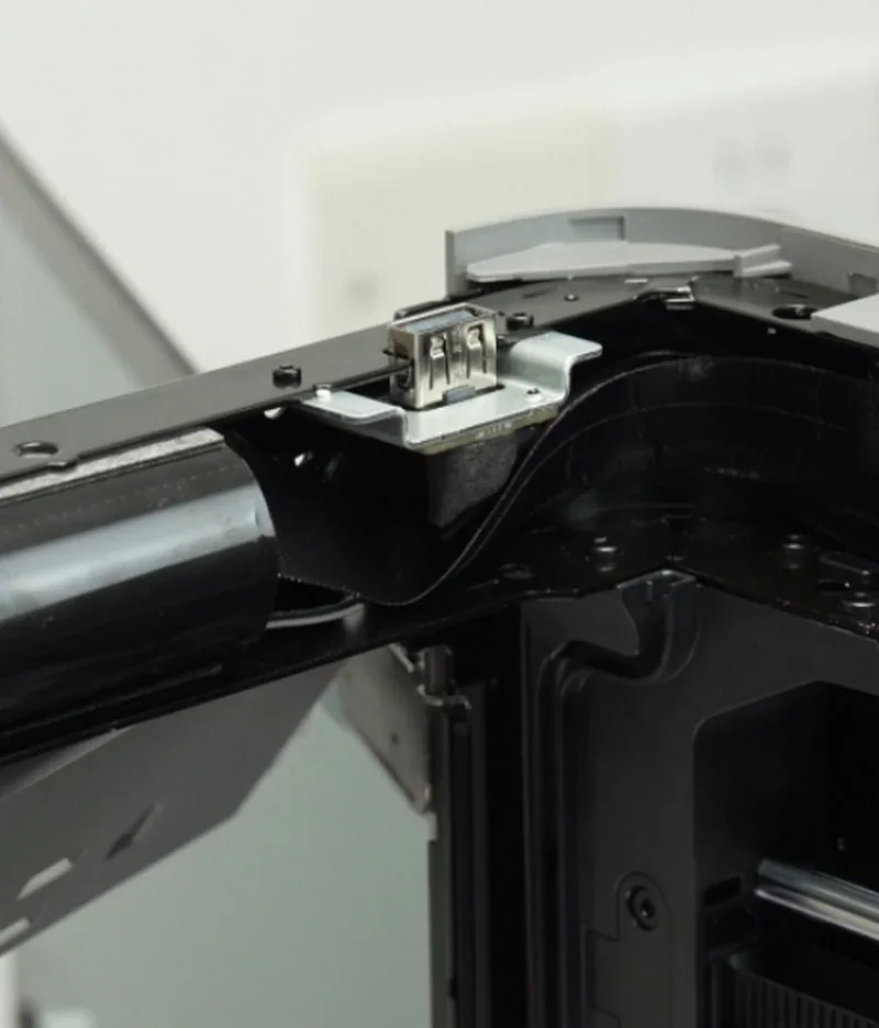 Close-up of Bambu P2S 3D printer's internal components, showcasing metal framing and wiring, highlighting detailed engineering and design.