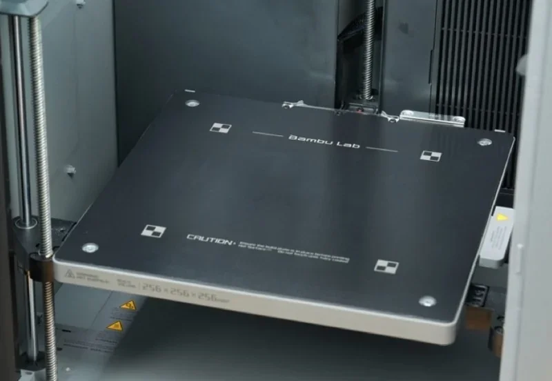 Bambu P2S 3D printer platform with branding and technical details, showcasing precise, sturdy build for high-quality part printing.