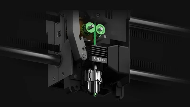 Bambu P2S 3D printer printhead close-up with green filament loaded, showcasing mechanical components and precision engineering in a dark setting.