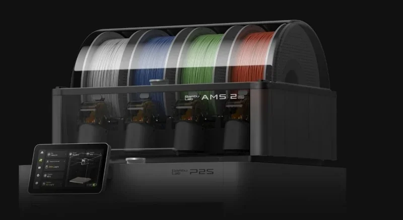 Bambu P2S 3D printer with AMS 2.5 filament system; includes white, blue, green, red spools; touchscreen interface visible on dark background.