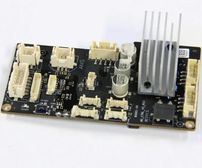 Bambu P2S control board with connectors and components on a dark circuit base, featuring capacitors and heatsink for 3D printer parts.