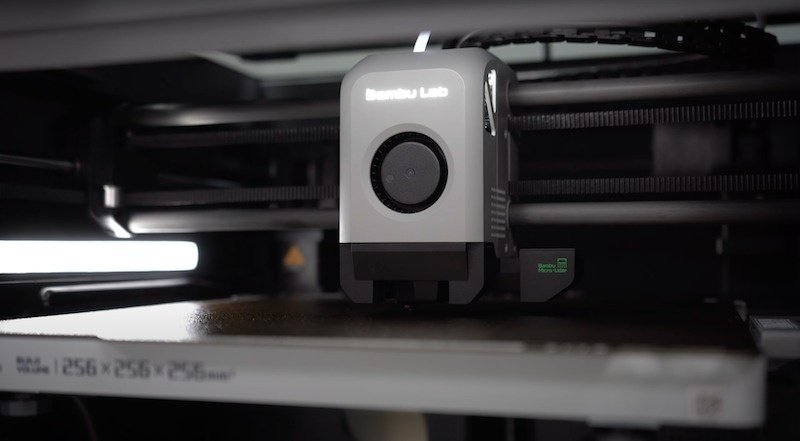 The internal mechanism of the Bambu Lab X1E 3D printer is shown, with a close-up of the printer's extruder and bed. The extruder bears the 