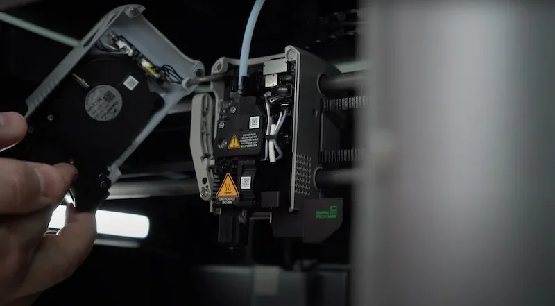 Bambu X1E 3D printer internal components, showcasing detailed wiring and assembly with warning labels, demonstrating precision engineering.