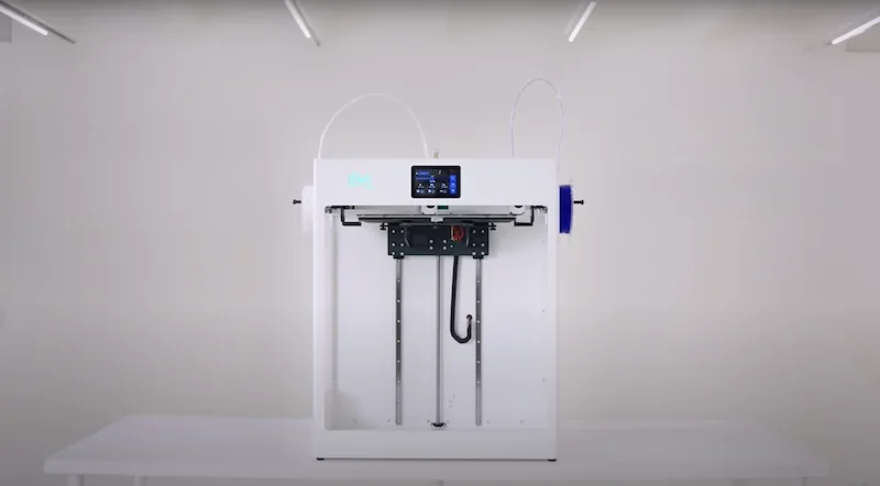 Craftbot Flow IDEX XL 3D printer in a minimalistic white setting with a touchscreen display, dual extruders, and visible filament spool on the right.