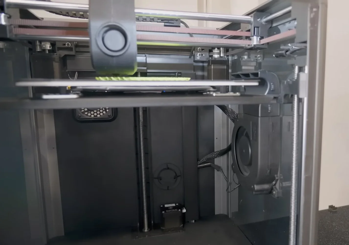 Creality K1 3D printer interior view, focusing on mechanics and print area, with internal components and wiring visible, showcasing advanced design.