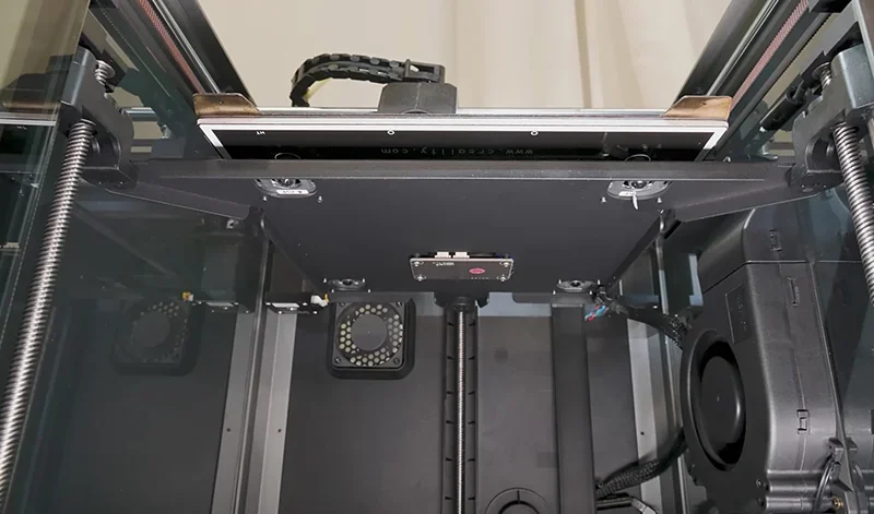 Creality K1 3D printer's internal mechanics, showcasing dual z-axis screws, cooling fans, and intricate components.