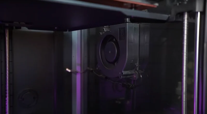 Creality K1 Max 3D printer interior showing printing components and mechanisms, highlighted by soft lighting, with partially visible branding.