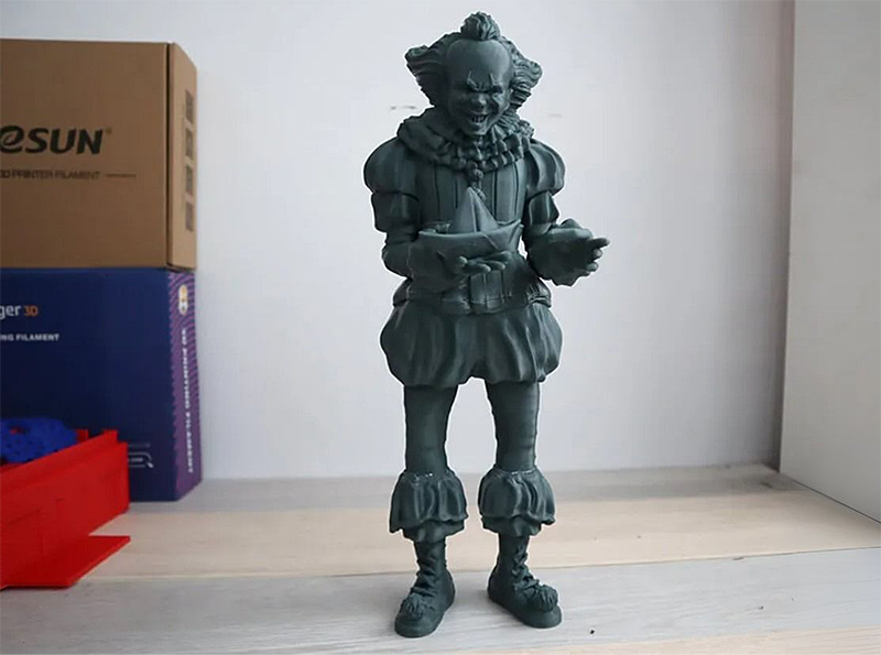 Creality K1 Max 3D printed clown figure on a table, with boxes and a red tray in the background.