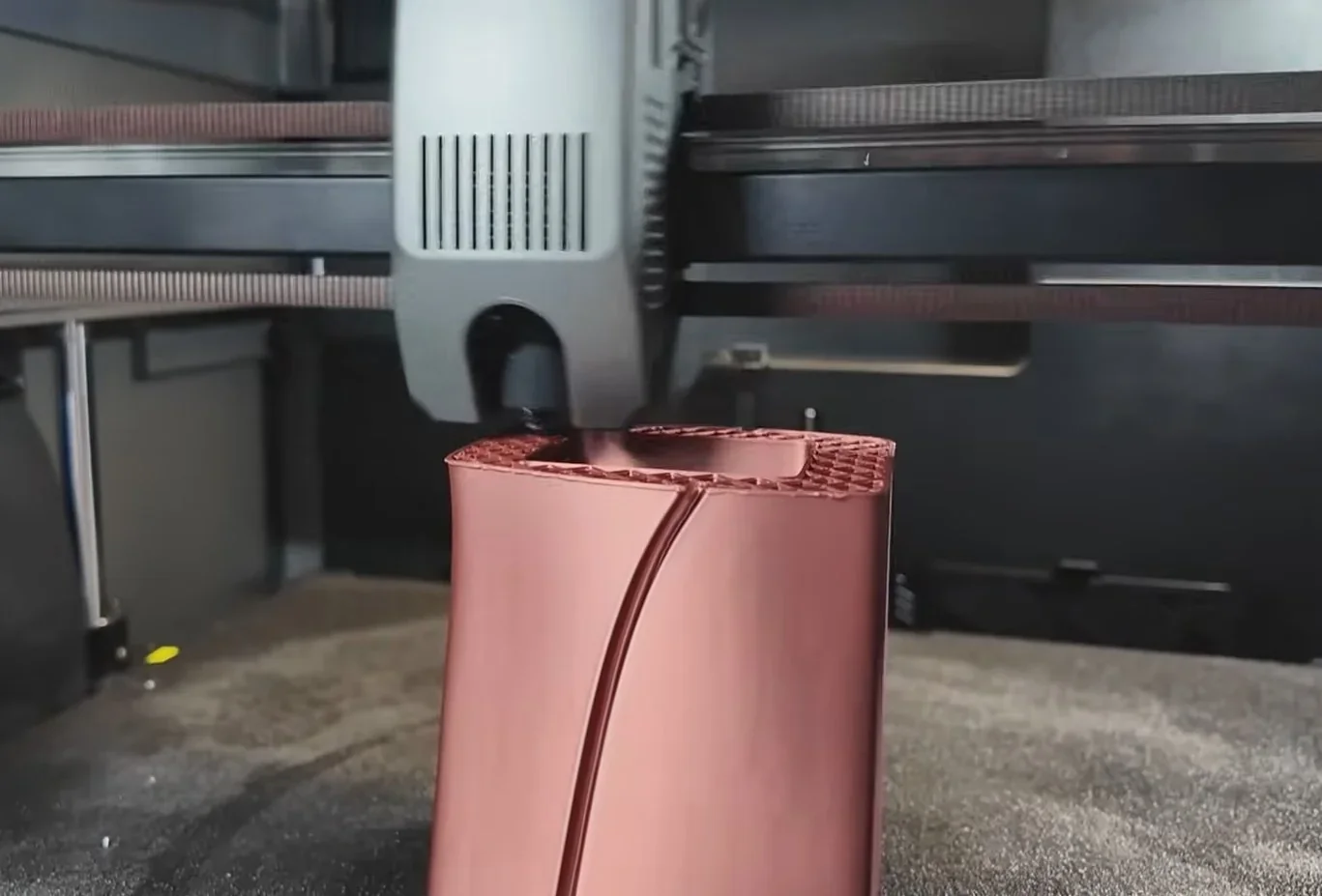 Creality K2 3D printing a red vase with intricate patterns in a modern setup, showcasing precise and detailed craftsmanship.