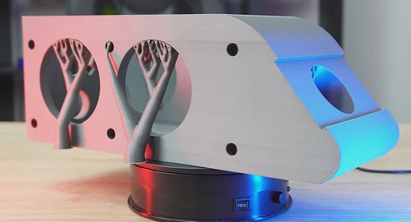 Creality K2 3D printer-created part with dual ventilation structures, set on a rotating platform, featuring sleek design and color lighting.
