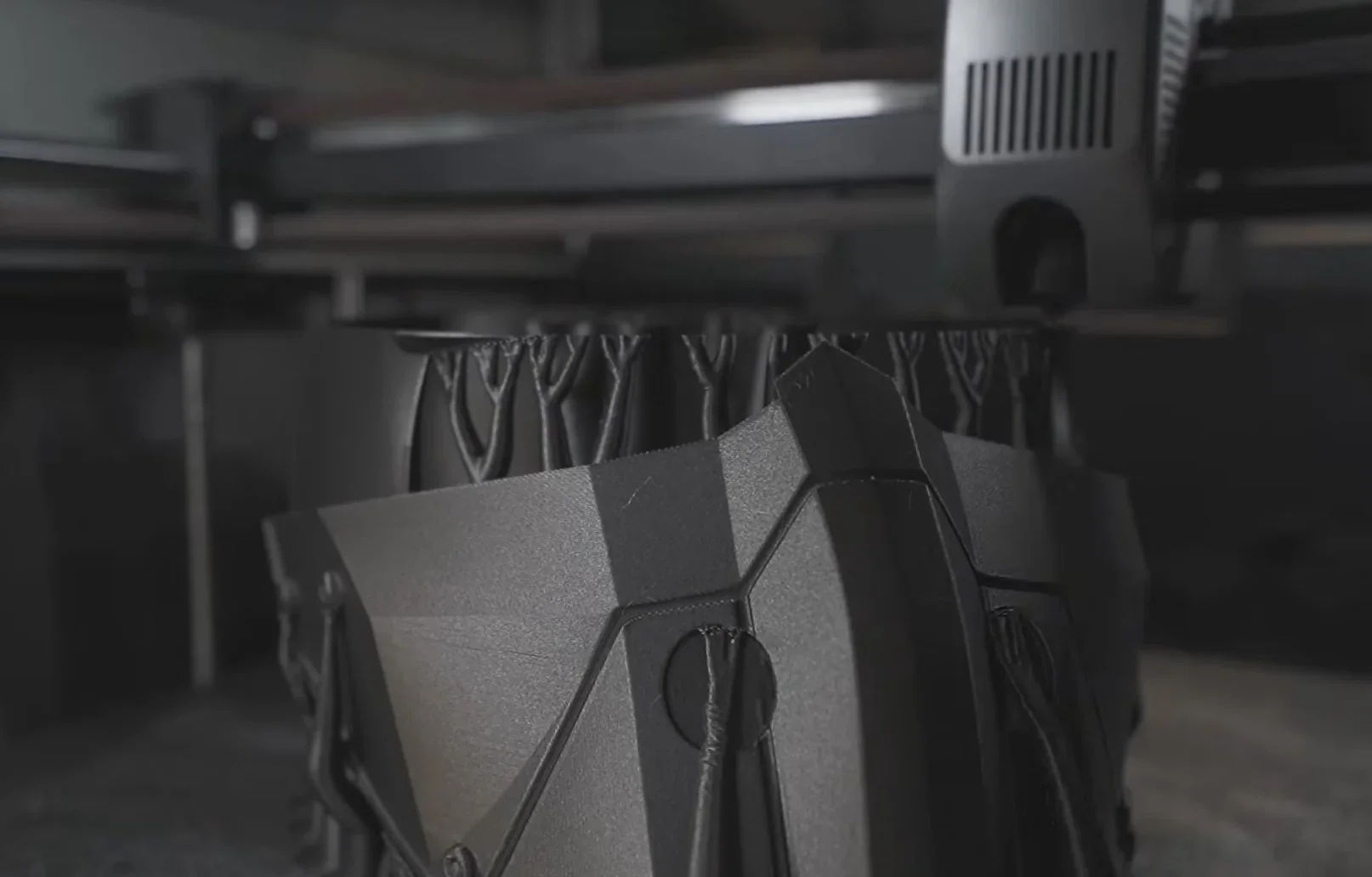 Creality K2 printer creating a detailed, geometric black object with tree-like structures, close-up view of printing process.