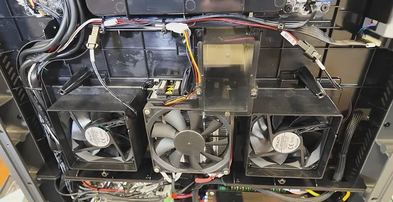 Creality K2 3D printer internal view with three cooling fans, wiring, and electronic components, showcasing detailed engineering and assembly.