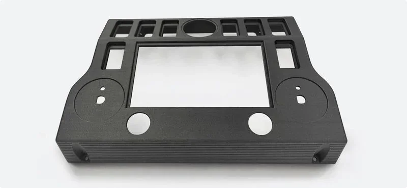 Black plastic component with symmetrical cutouts and rectangular center, likely 3D printed by the creatbot d1000, on a neutral background.