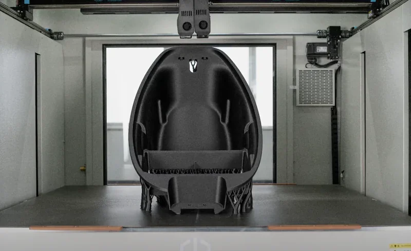 Creatbot D1000 Pro HS 3D printer with a large, intricately designed black seat print inside the printer chamber, showcasing build capacity.