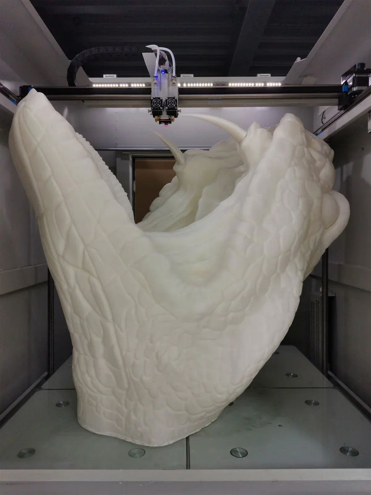 CreatBot D1000 Pro HS printing large, detailed white sculpture with smooth and textured surfaces inside a metal enclosure.