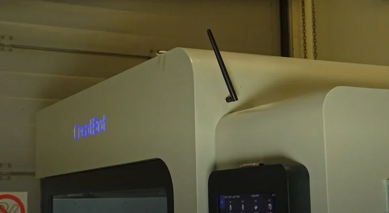 Creatbot D1000 Pro HS 3D printer showing its top section with branding, antenna, and control panel in an industrial setting.