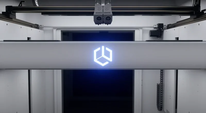 Creatbot D1000 Pro HS 3D printer interior with dual nozzles and glowing logo, showcasing precision engineering and advanced build capabilities.