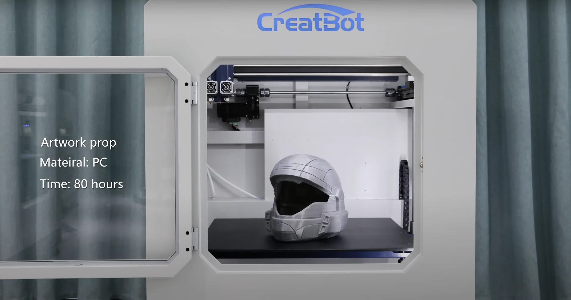 CreatBot D600 Pro with a printed helmet prop displayed inside, logo on top, and curtains in the background.